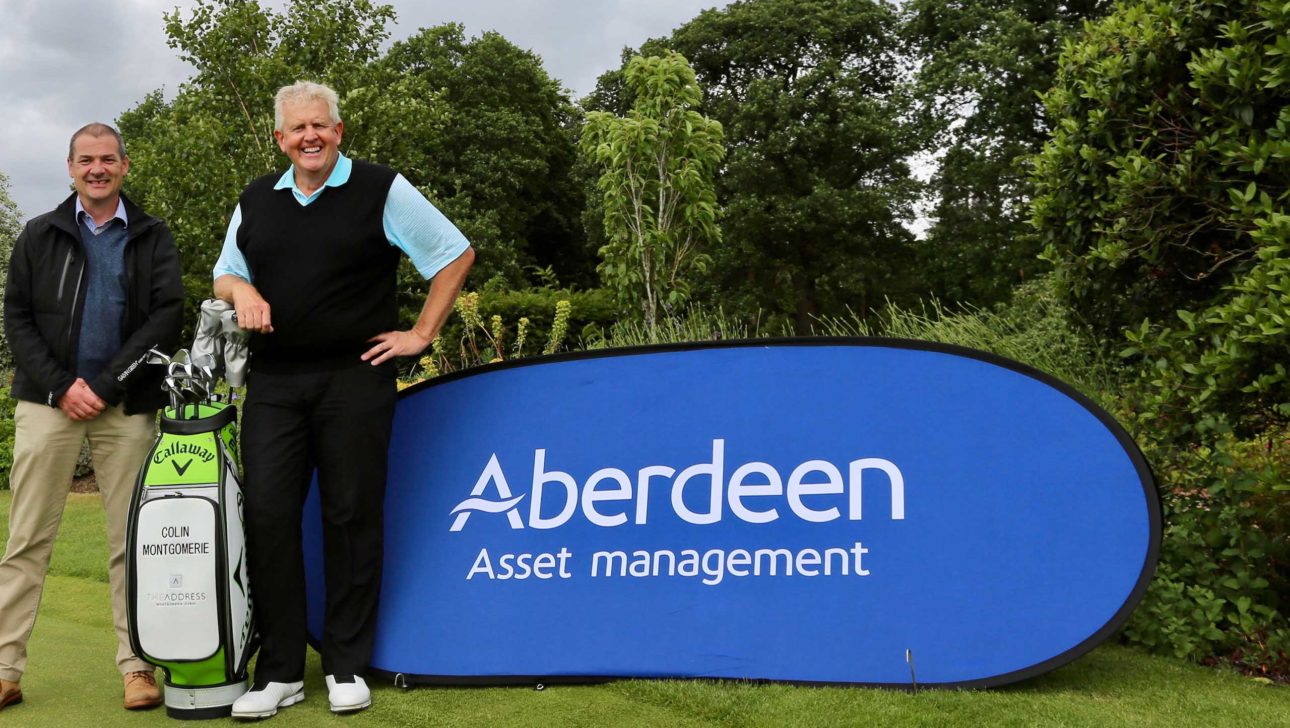 A man standing in front of a sign with the Aberdeen logo.